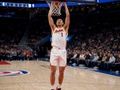NBA季前赛篮球比赛现场，球员在空中扣篮的精彩瞬间