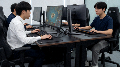 DOTA2职业比赛中两队选手对峙的现场，选手全神贯注盯着屏幕操作英雄